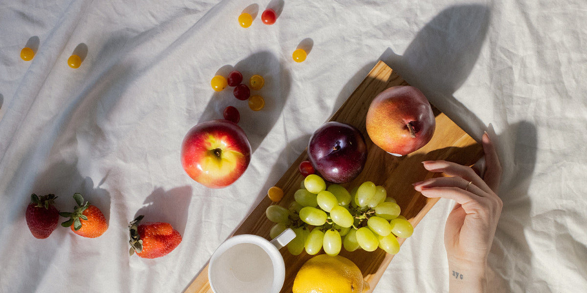 Obst auf einer weißen Decke ausgebreitet und von der Seite vom Sonnenlicht angestrahlt