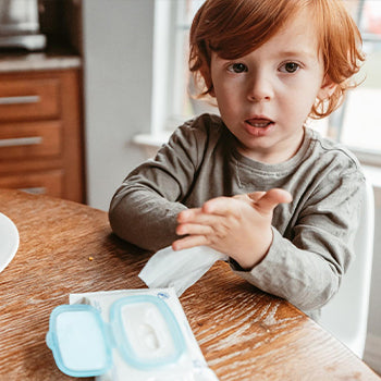 Child cleaning his hands after eating