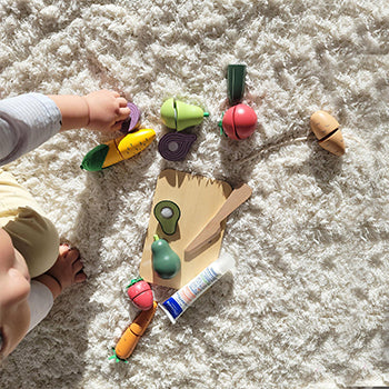 1 year old baby playing with plastic fruit toys