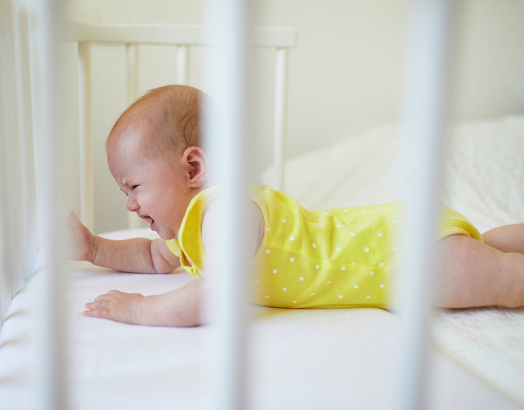 baby in crib experiencing 3-month sleep regression