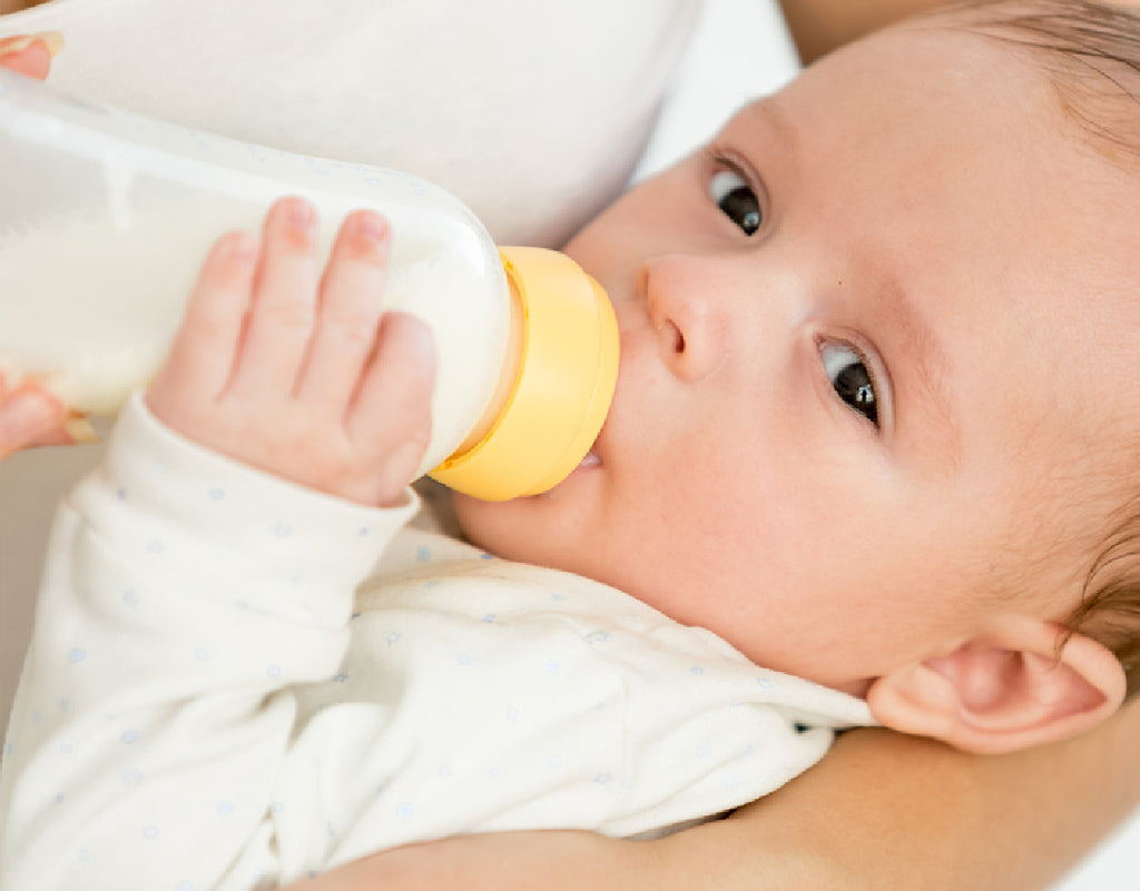 baby drinking a bottle on a 3 month old feeding schedule