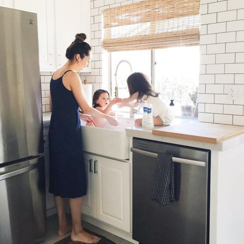 Woman bathing her children in the sink