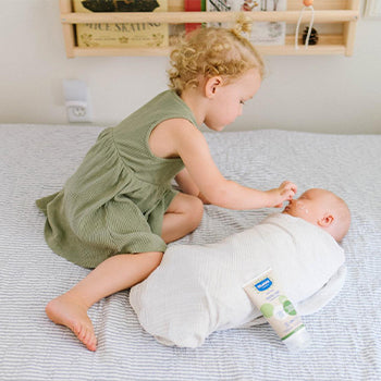 Older siblings using aloe vera benefits by rubbing on baby