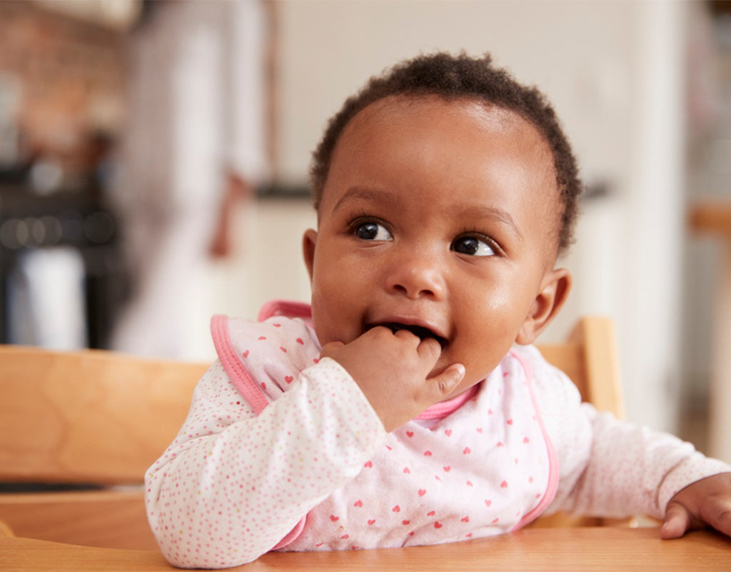 Baby with fingers in mouth during feeding