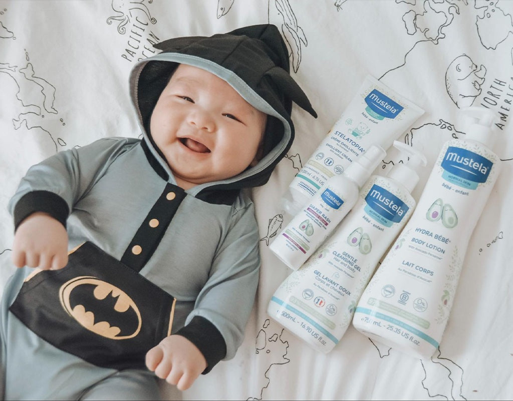 baby boy laying with mustela baby products