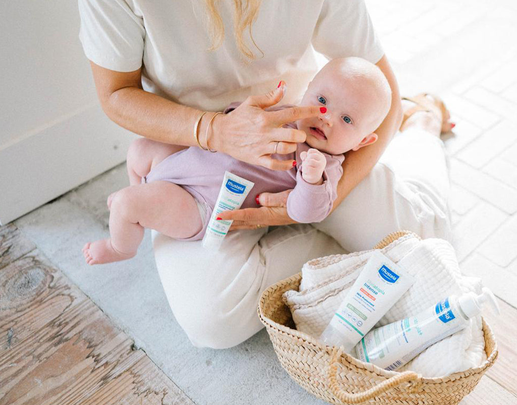 Mom applying cream to baby's eczema on face