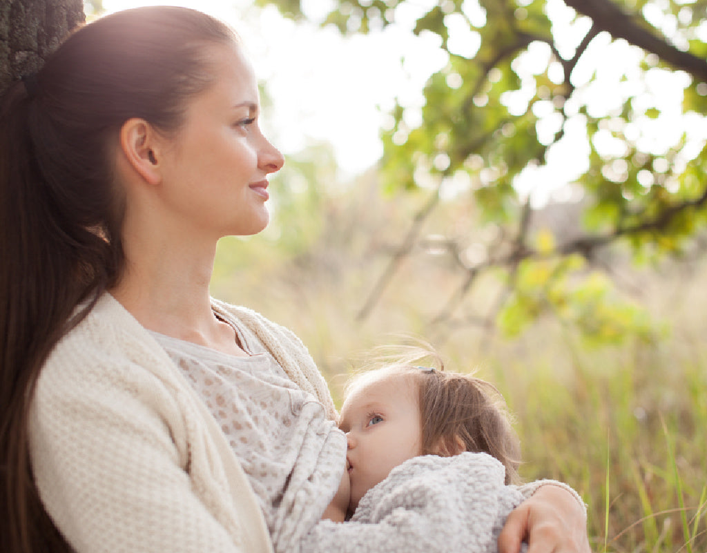 Mom breastfeeding child outside