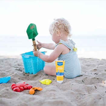 Baby playing in sand at the beach