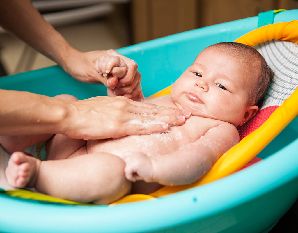 Parent giving baby's first bath