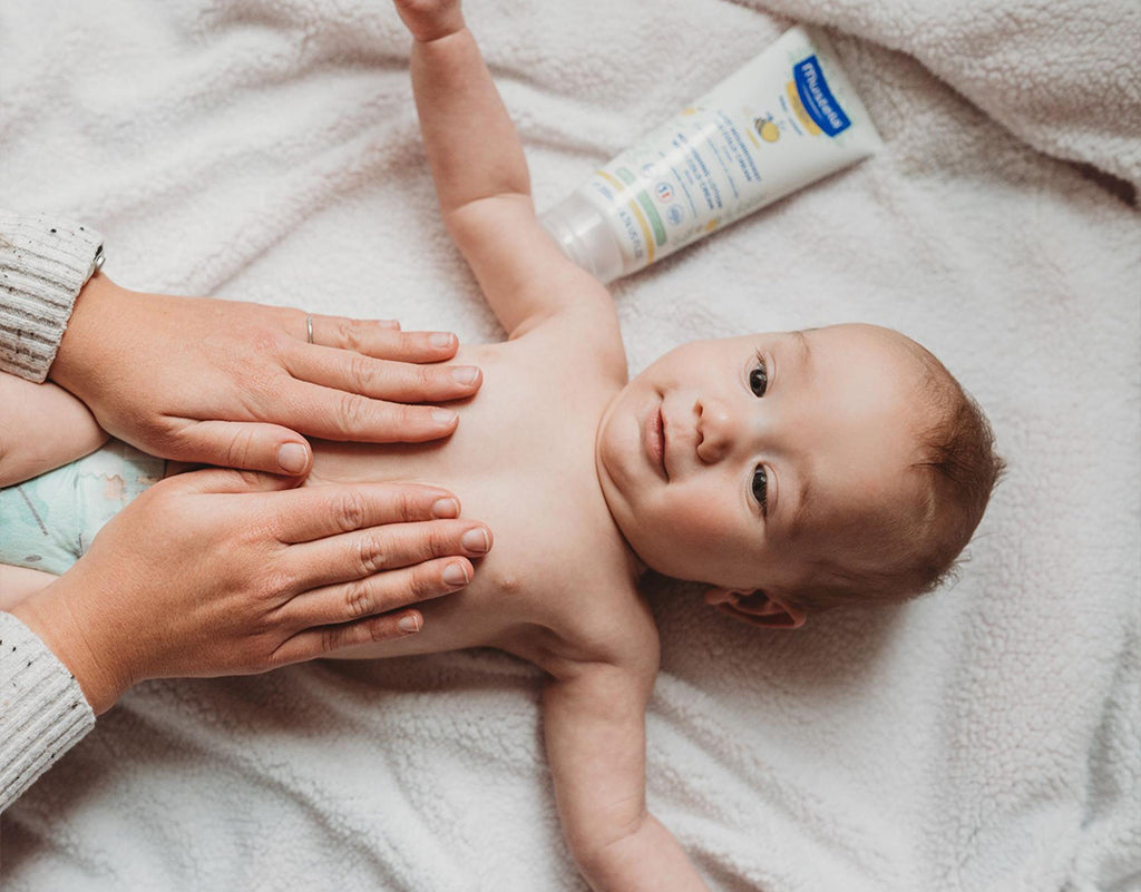 Mom applying lotion on baby after baby's first bath