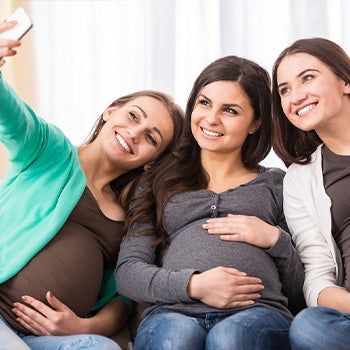 Pregnant friends taking pictures and playing baby shower games
