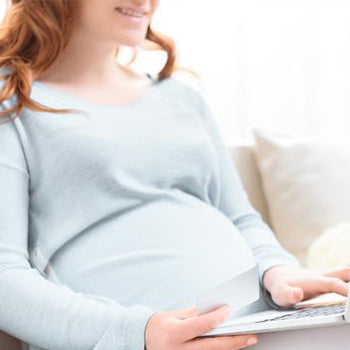 Pregnant mom on computer searching for virtual baby shower ideas