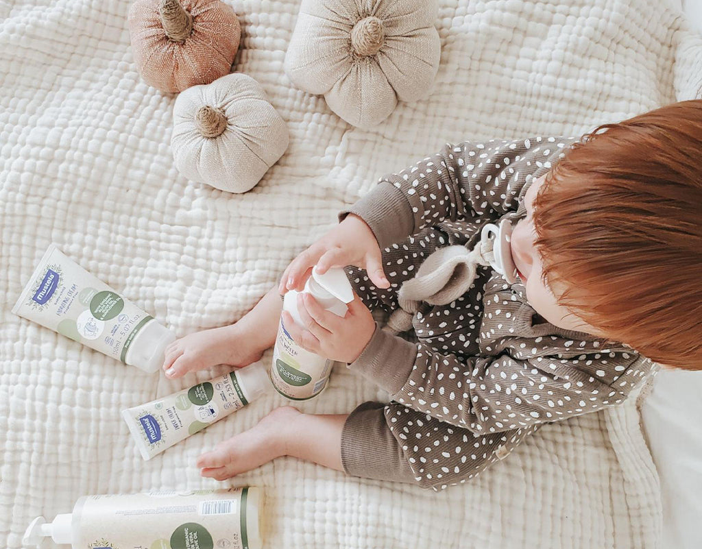 Baby playing with baby skin care products