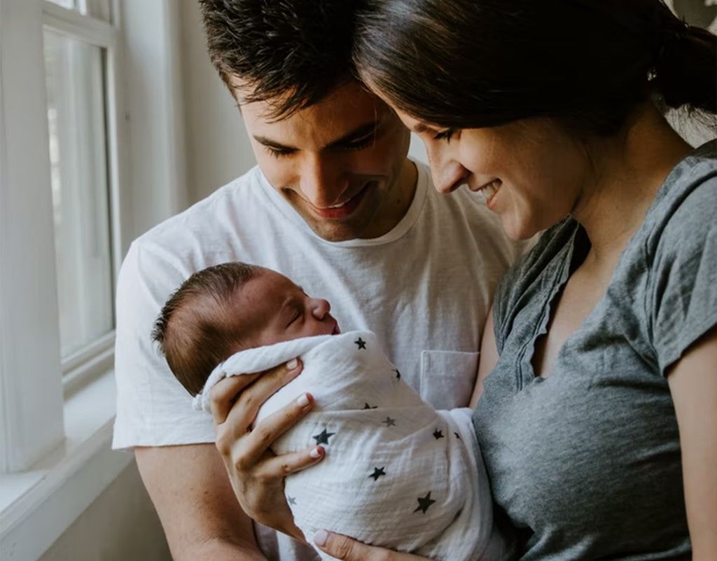 Parents holding newborn while thinking of birth announcement ideas