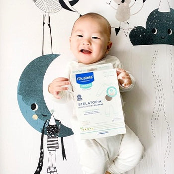 Baby wearing stelatopia skin soothing pajamas to help with bug bites on baby