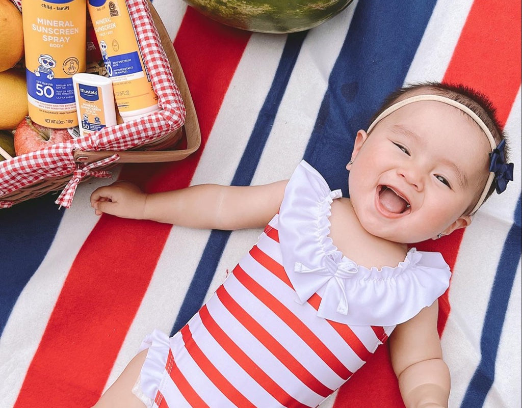 Baby in the sun with mustela sunscreen