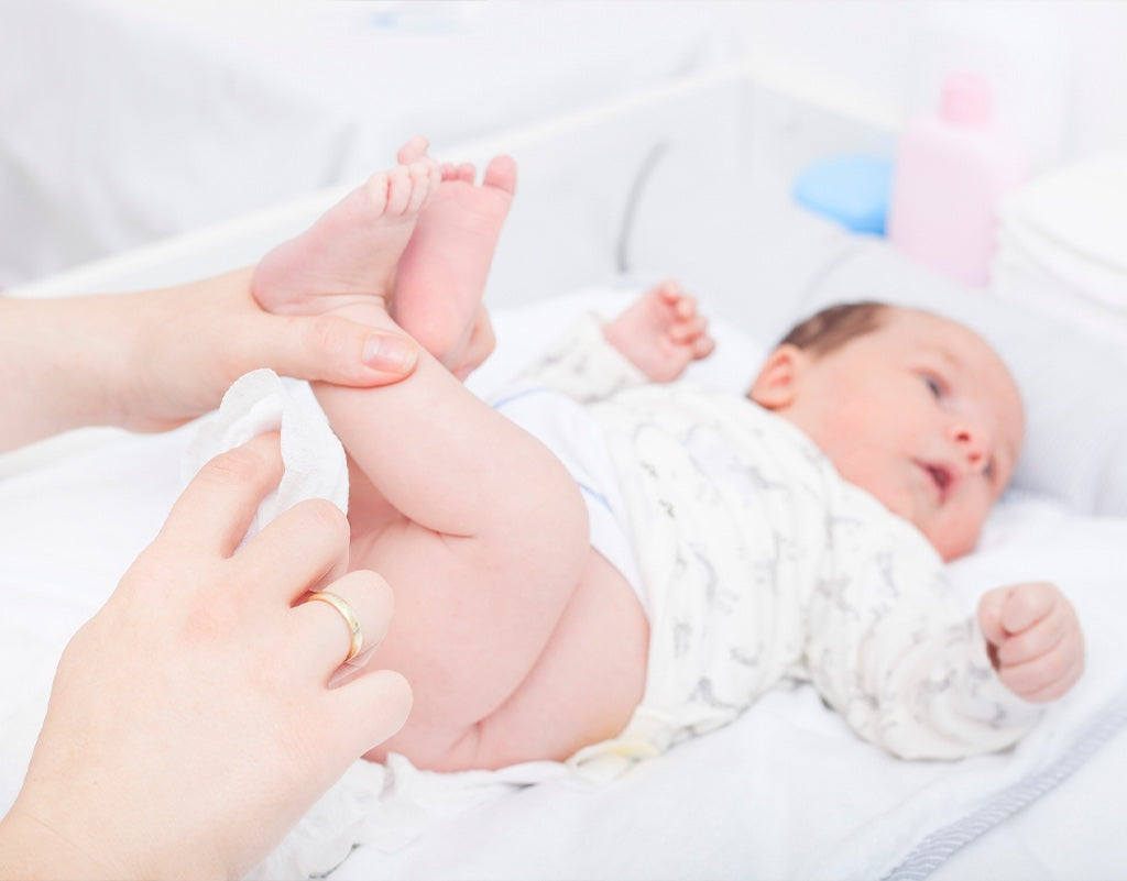 Parent using baby wipe cloths while changing a diaper 