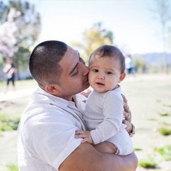 Dad kissing baby