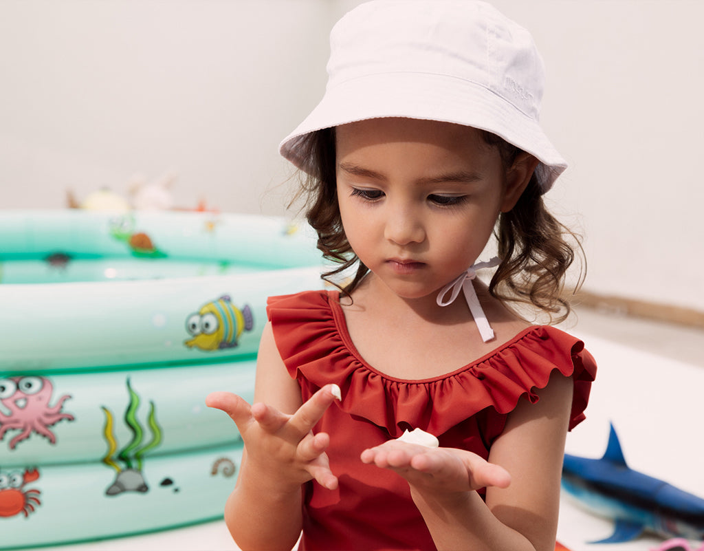 Young girl applying daily sunscreen