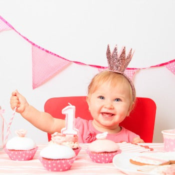 1 year old baby girl with pink birthday decorations