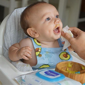 6 month old baby enjoying mashed avocados