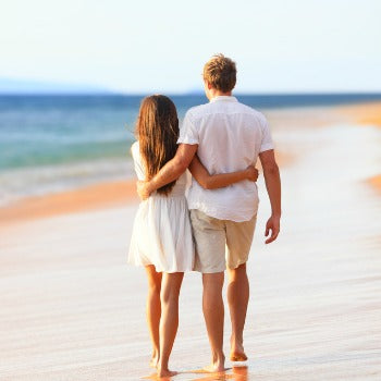 Man and woman on a beach babymoon