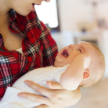 mom holding crying baby