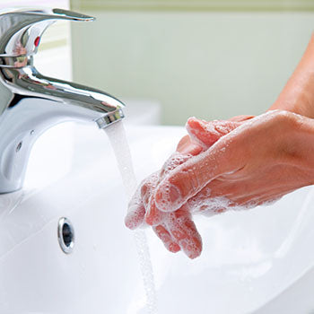 woman washing hands at a bathroom sink