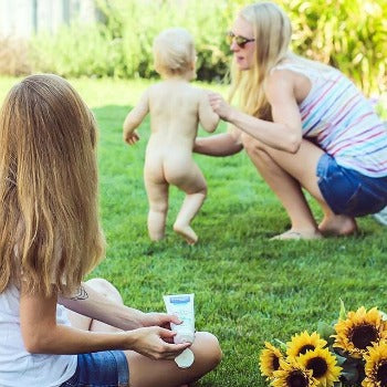 Mother and baby playing outdoors with young girl