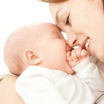 mother holding baby and nuzzling against her face