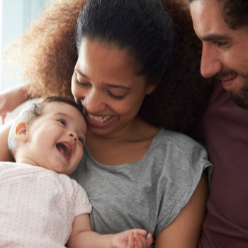 Mom and dad holding smiling baby