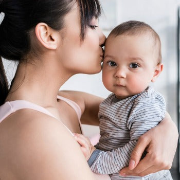 mom kissing baby