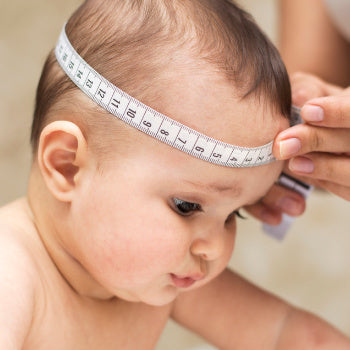 baby having head measured for growth chart
