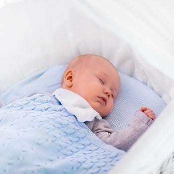 baby sleeping in a bassinet which is an important area to consider on a baby registry checklist