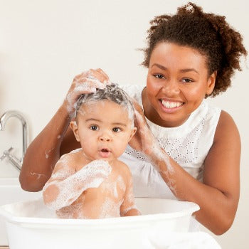 mother bathing baby in baby bathtub