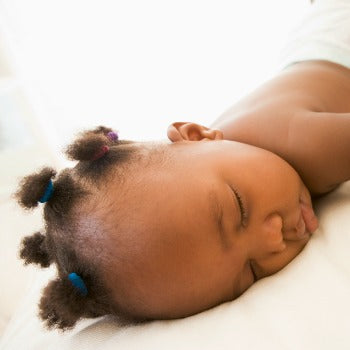 baby girl in diaper resting on her tummy 