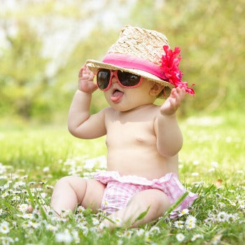 baby playing in the shade with protective sunglasses and hat