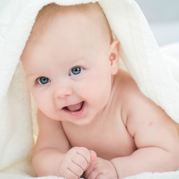happy baby playing under towel