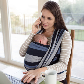 mom working while holding baby in sling