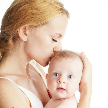 side view of mother holding and kissing baby's head