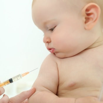 baby looking down as physician holds immunization needle near his arm