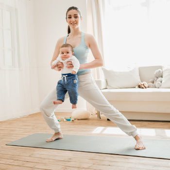 Mom doing postpartum exercise with baby
