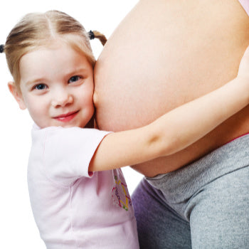 toddler hugging moms pregnant belly