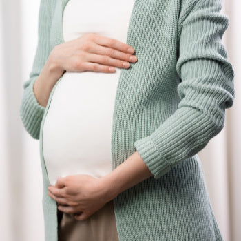 woman in second trimester holding her pregnant belly