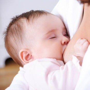 mother breastfeeding content baby in pink outfit 