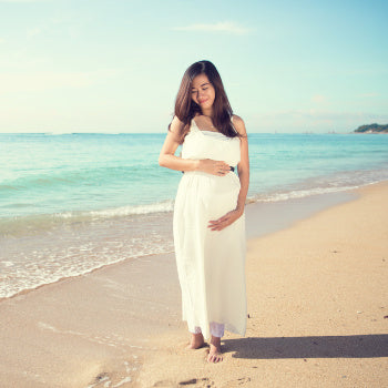 pregnant woman sunbathing and walk at the beach