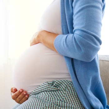Woman in her third trimester holding her belly