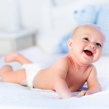 giggling baby lying on bed