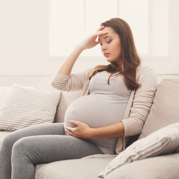 woman on couch thinking about her twin pregnancy
