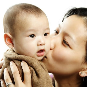 mother kissing happy baby after wet wrapping